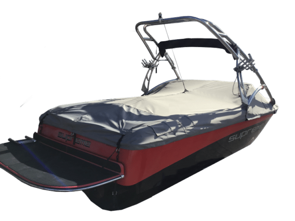 Red and black motorboat with a gray cover and metal frame, viewed from the rear.