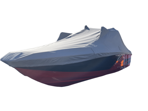 A boat is covered with a fitted gray tarp, concealing most of its features. The hull is mainly red with some blue visible.