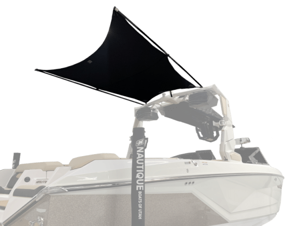 A white Nautique boat with a black canopy overhead, displayed in a showroom setting.