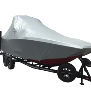 A boat covered with a gray tarp sits on a double-axle trailer.