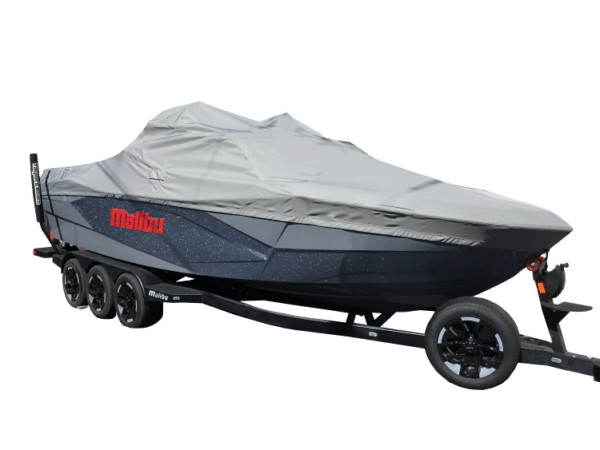 A covered black boat is on a trailer with three wheels on each side. The boat has a grey protective cover and the word "Malibu" in red on the side.