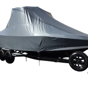 A boat covered with a gray protective tarp sits on a trailer with black wheels.