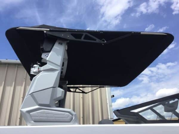 A mounted radar or communication device with a black cover on a building rooftop, set against a partly cloudy sky backdrop.